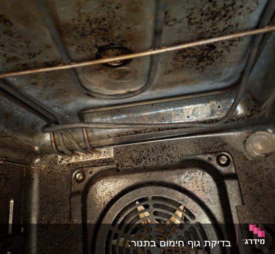 מבט לפנים תא אפייה של תנור חשמלי עם גוף חימום ומאוורר